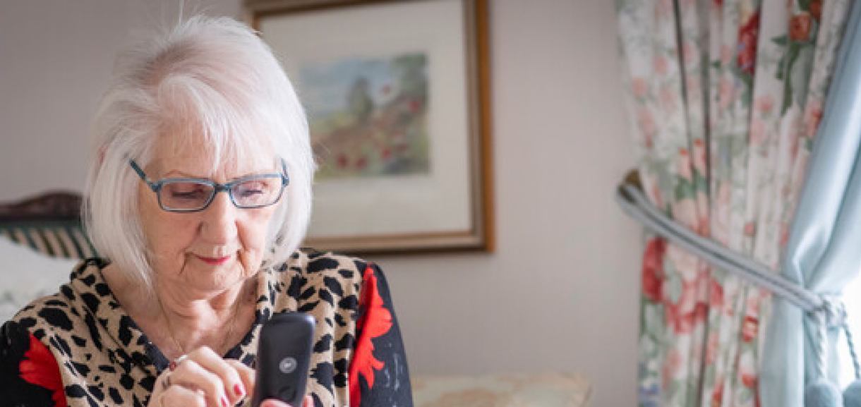 A photo of a woman typing a number into house phone